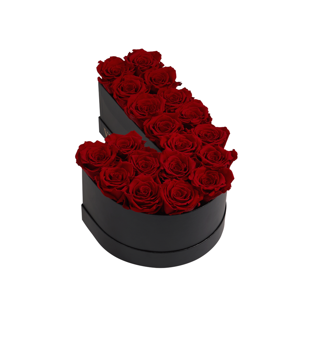 Black box shaped like the letter J filled with red roses arranged neatly inside.