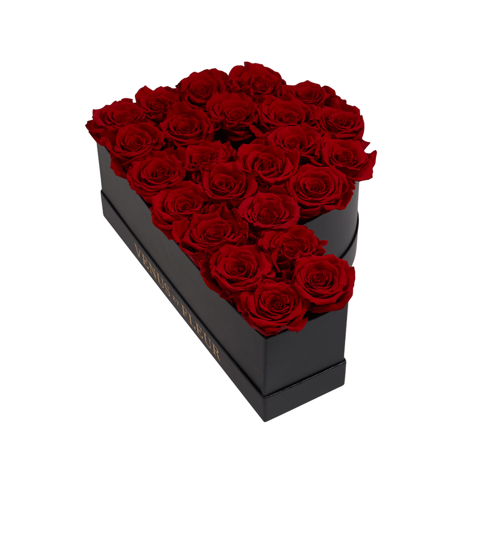 Black box shaped like the letter P filled with red roses, with gold text 'VENUS ET FLEUR' on the side
