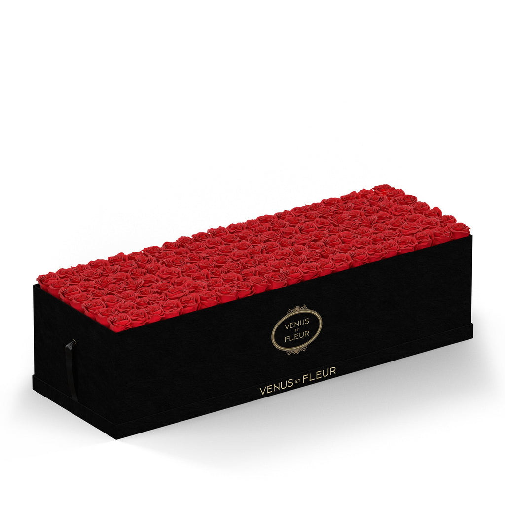 Rectangular black box filled with red roses, with 'VENUS ET FLEUR' text on the front and side of the box.