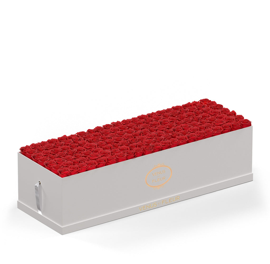 Rectangular white box filled with red roses, branded with 'VENUS ET FLEUR' in gold lettering
