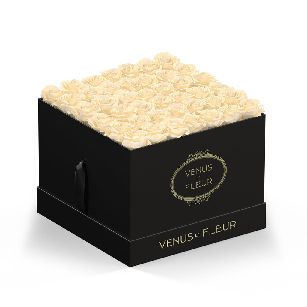 Black square box filled with cream-colored roses, branded with 'VENUS ET FLEUR' on the front and base.