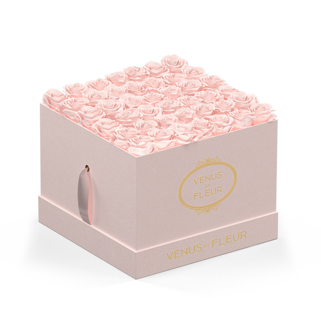 Pink square box filled with pink roses, branded with 'VENUS ET FLEUR' in gold lettering