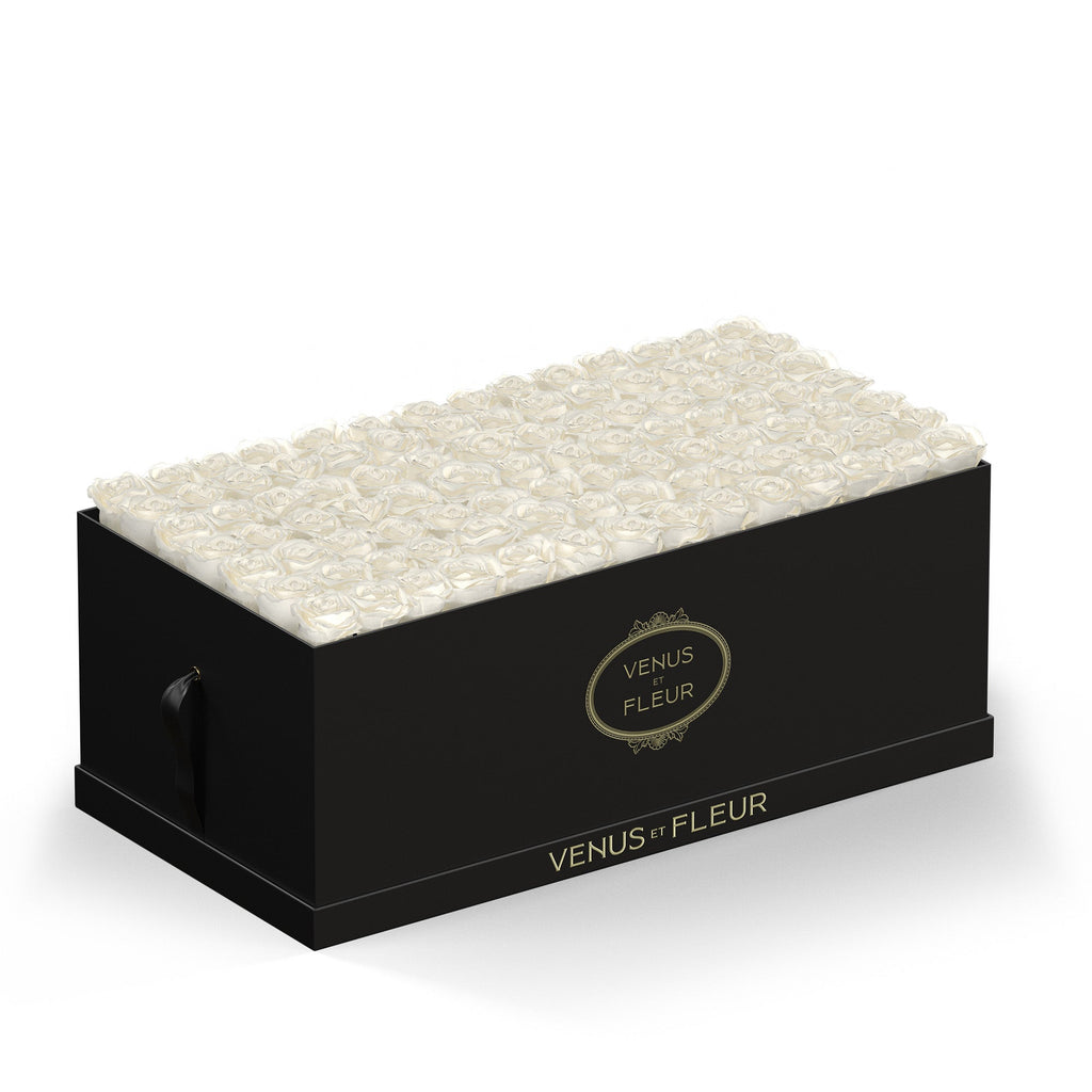 Black rectangular box filled with white roses, with gold text 'VENUS ET FLEUR' on the side and front of the box.