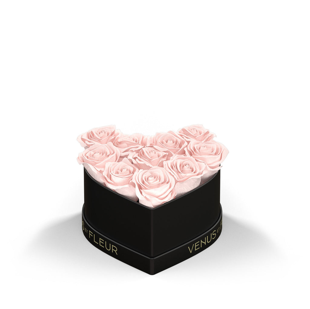 Heart-shaped black box with pale pink roses inside and the text 'VENUS ET FLEUR' on the box.