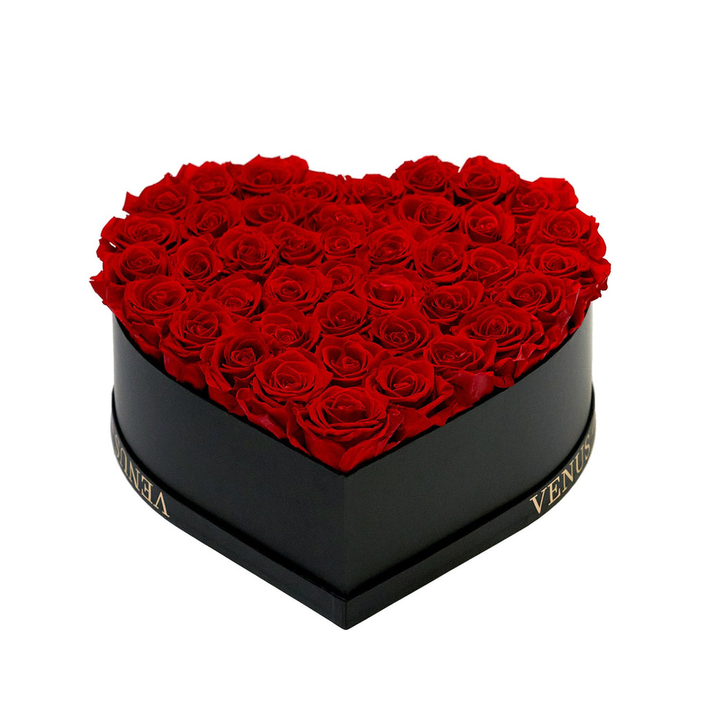 Heart-shaped black box filled with red roses, with the word 'VENUS' visible on the side of the box