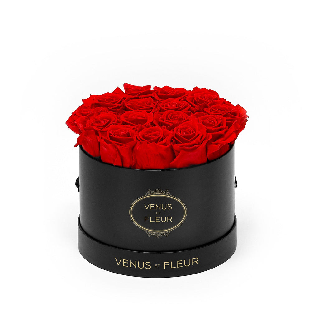 Black round box filled with red roses, labeled 'VENUS ET FLEUR'