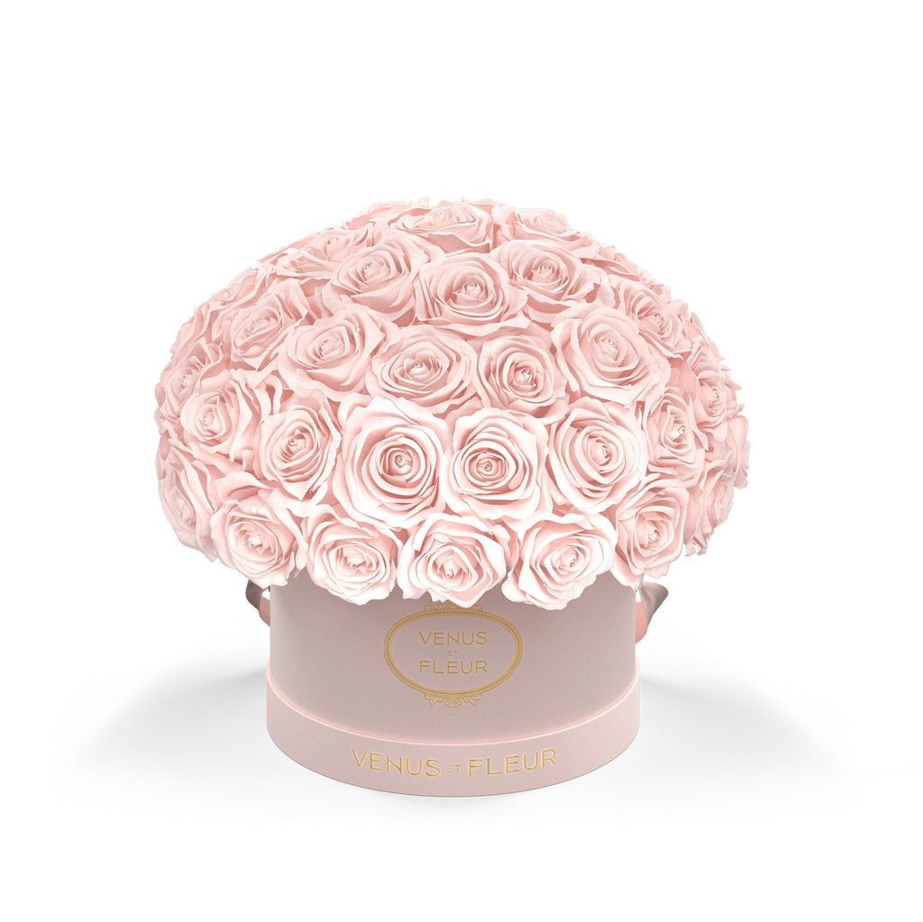 Pink round box with many light pink roses arranged on top, with gold text 'VENUS ET FLEUR' on the box.