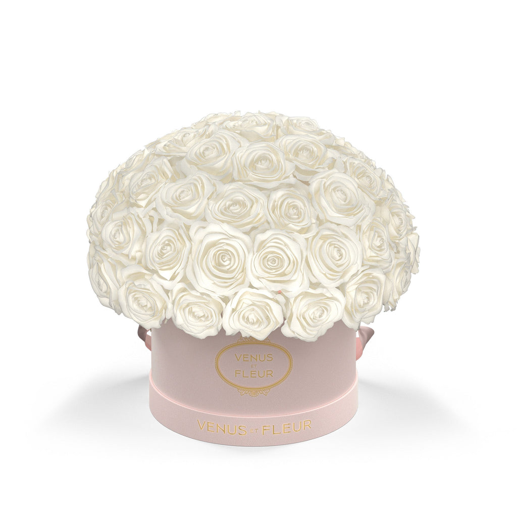 Bouquet of white roses in a pink round box labeled 'VENUS ET FLEUR'