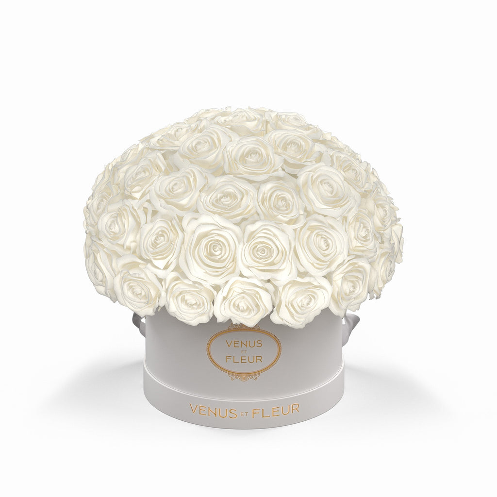 White roses arranged in a round white box with gold text 'VENUS ET FLEUR' on the front and base of the box