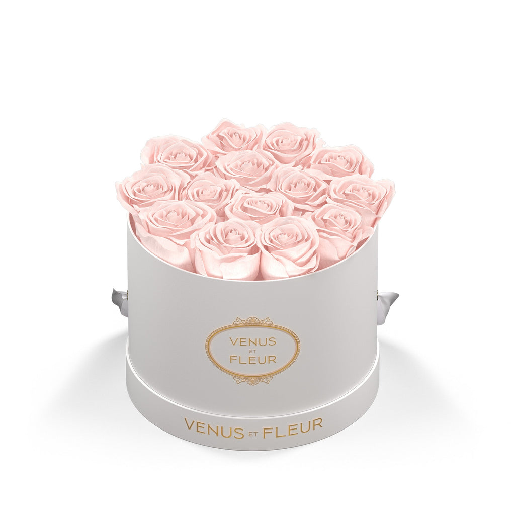 Round white box with light pink roses arranged inside, labeled 'VENUS ET FLEUR' on the front and base.