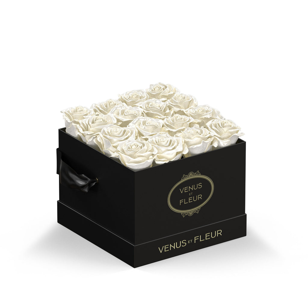 Black square box filled with white roses, with the text 'VENUS ET FLEUR' on the front and side of the box.