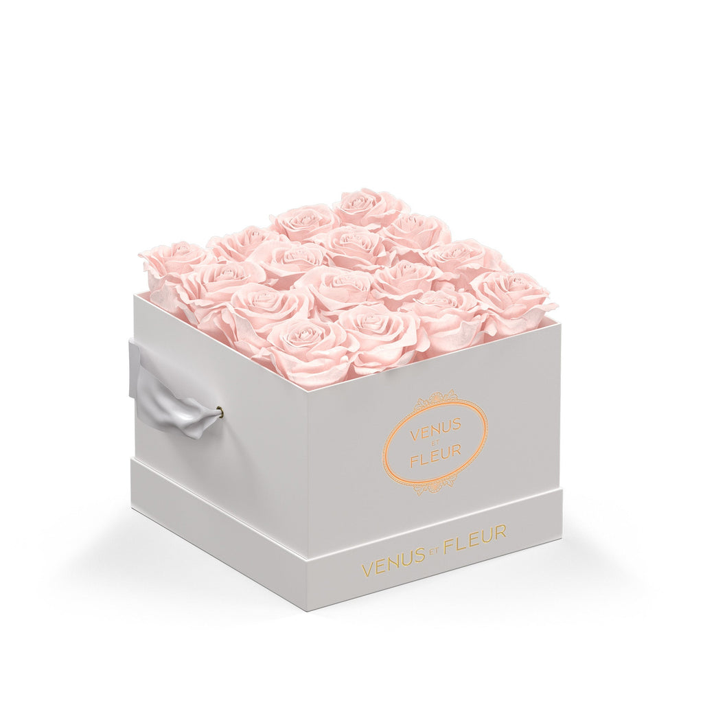 White square box filled with pale pink roses, with gold text 'VENUS ET FLEUR' on the front and side of the box.