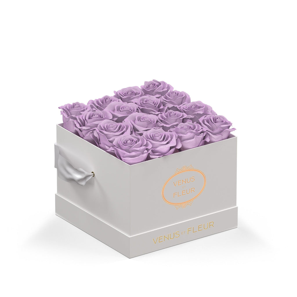Box of purple roses with the brand name Venus et Fleur on the front and side of the white box