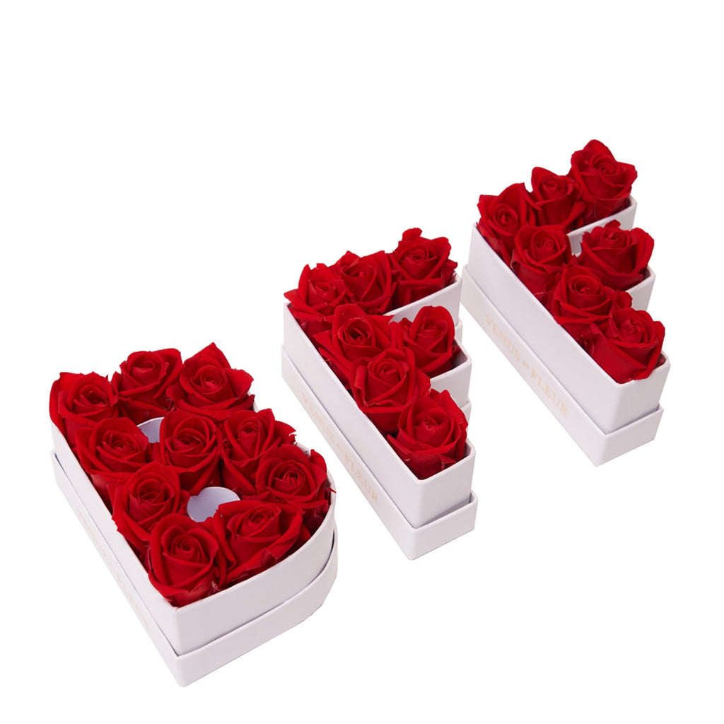 Three white boxes shaped as the letters D, I, and Y, each filled with red roses arranged neatly inside.