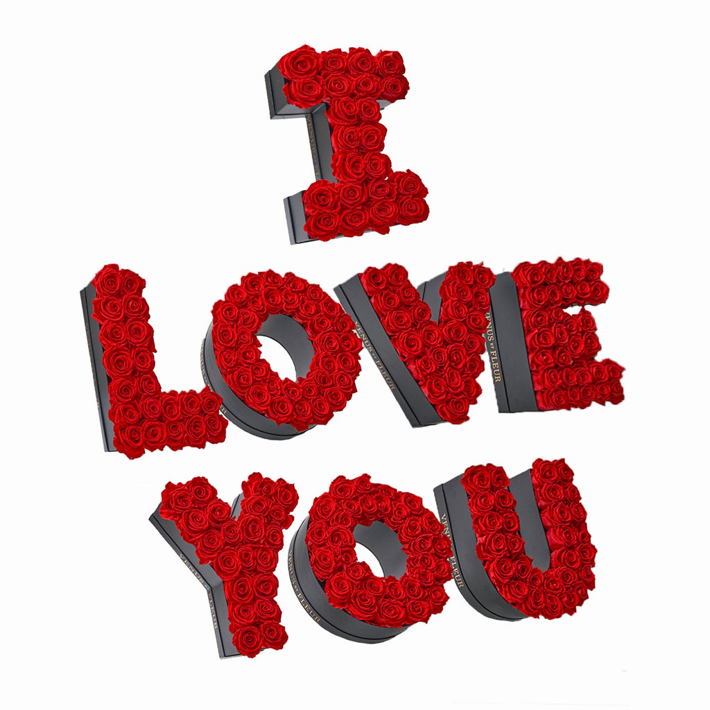 Floral arrangement of red roses spelling out 'I LOVE YOU' in black boxes