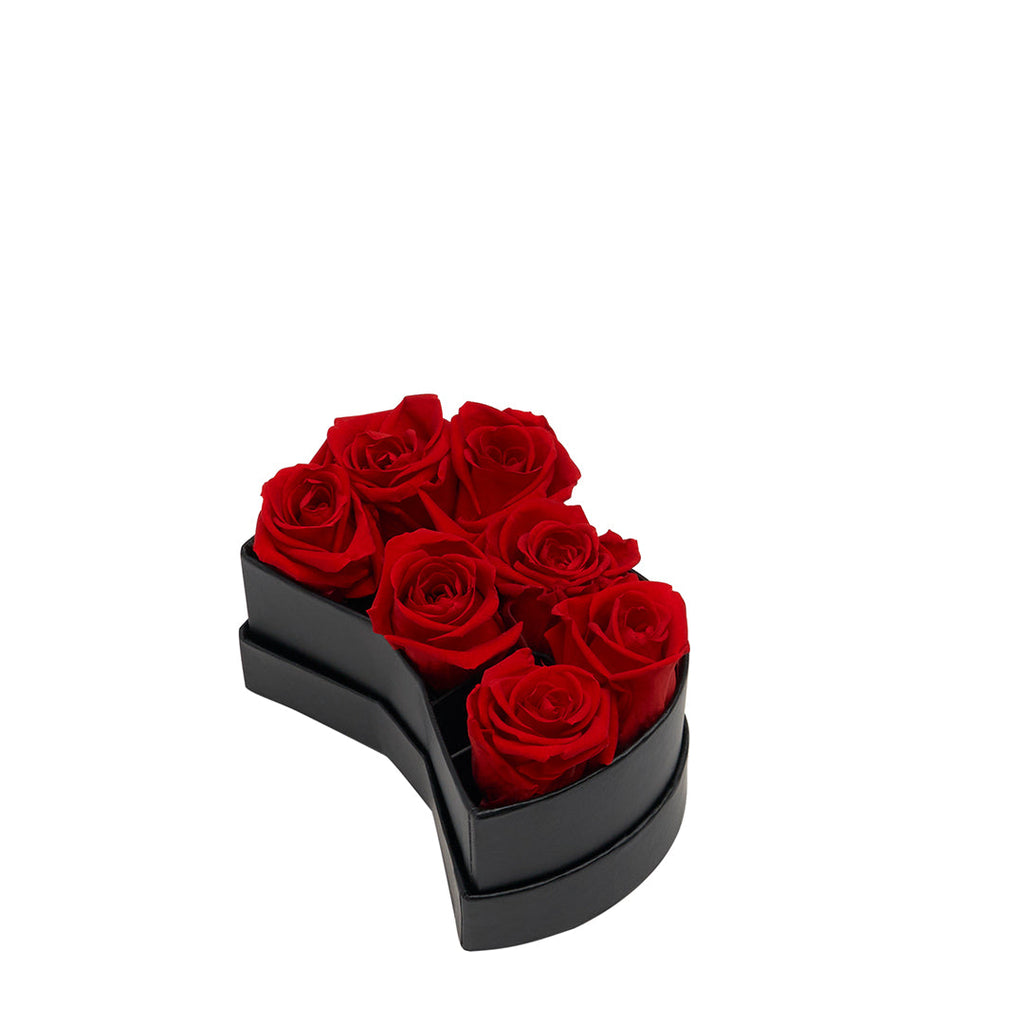 Black box shaped like the number 3 containing seven red roses arranged inside