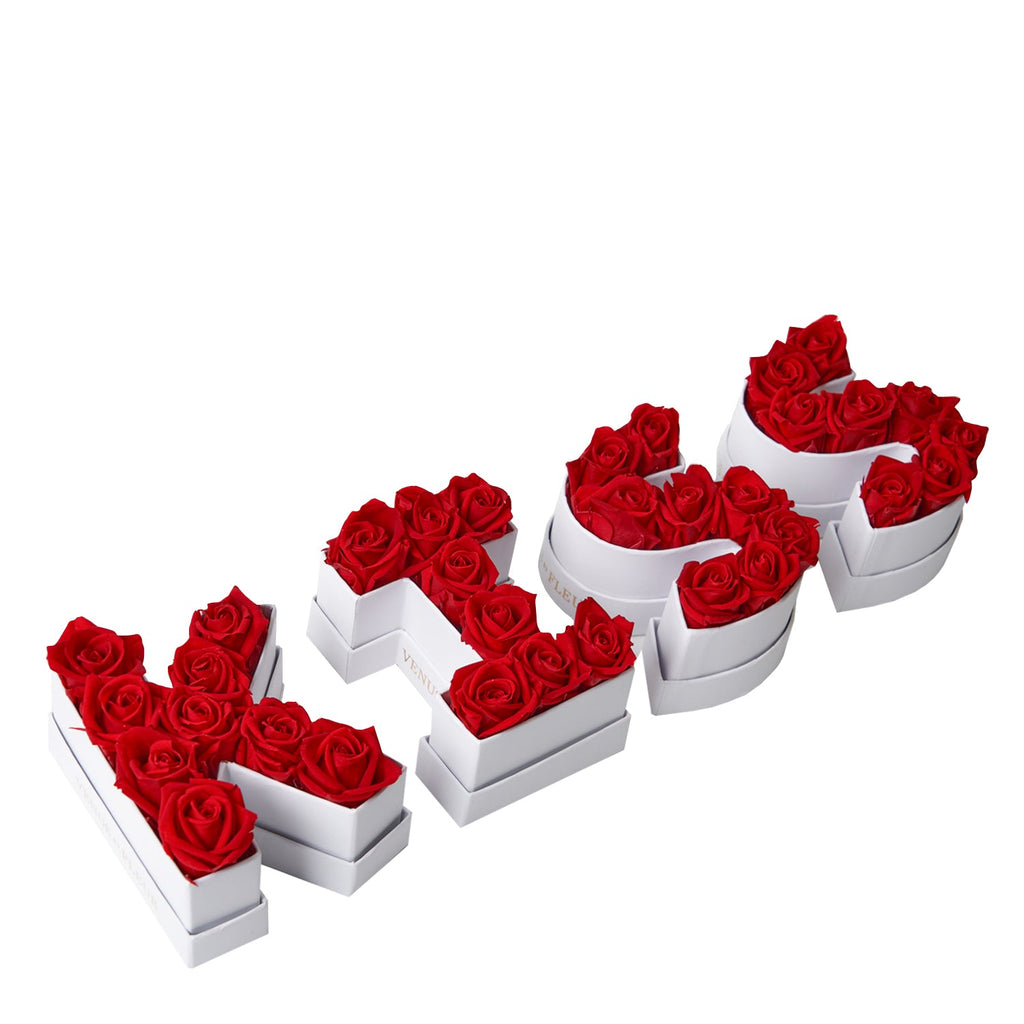 Red roses arranged in white boxes spelling the word LOVE