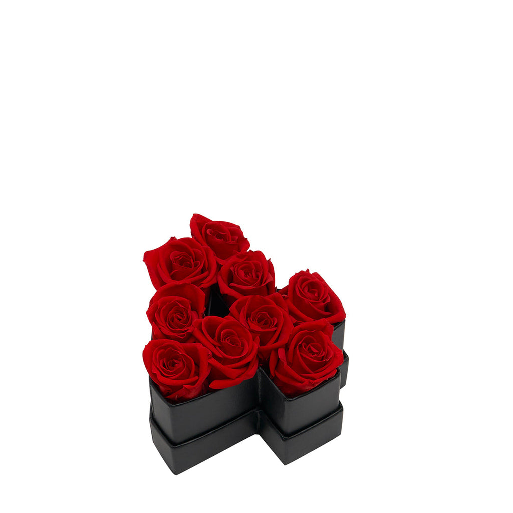 Black cross-shaped box containing nine red roses